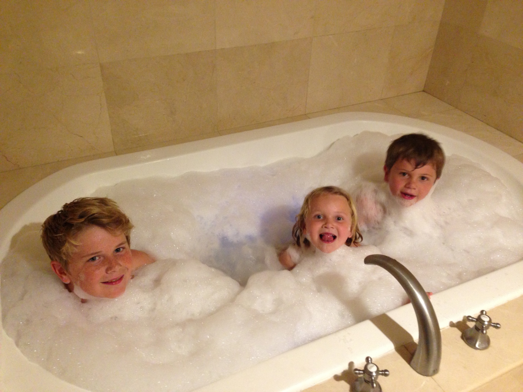 Indi in a bubble bath with her brothers
