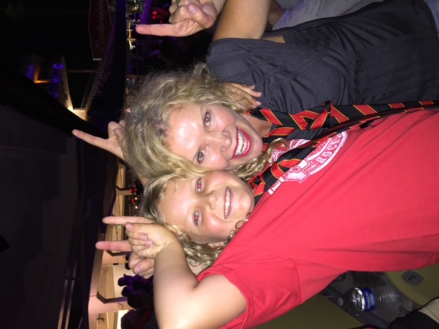 Indi and mom at a concert throwing rock-on hands
